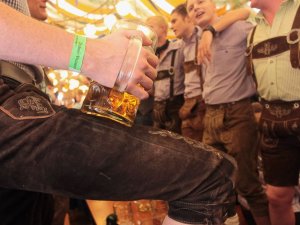 PHOTO: Revellers dressed with traditional Bavarian Lederhosen trousers enjoy drinking beer